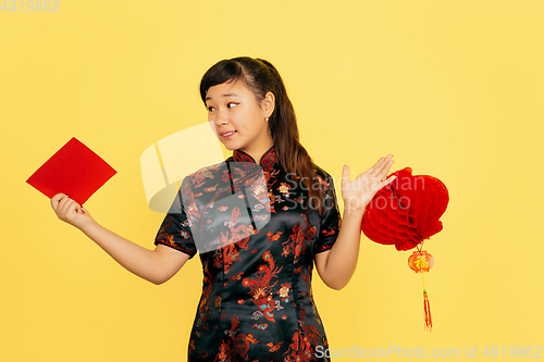 Image of Happy Chinese New Year. Asian young girls\'s portrait isolated on yellow background