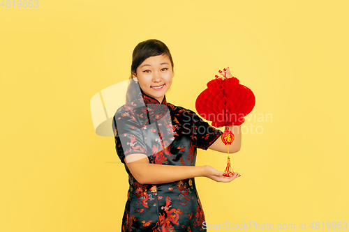 Image of Happy Chinese New Year. Asian young girls\'s portrait isolated on yellow background