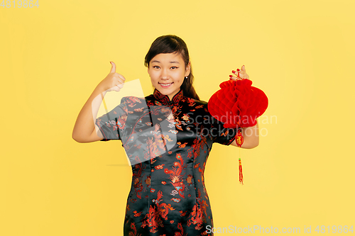 Image of Happy Chinese New Year. Asian young girls\'s portrait isolated on yellow background