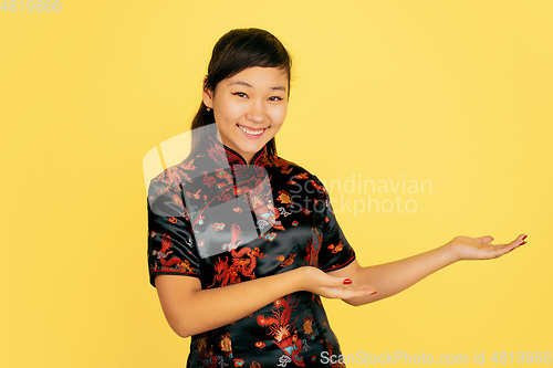 Image of Happy Chinese New Year. Asian young girls\'s portrait isolated on yellow background