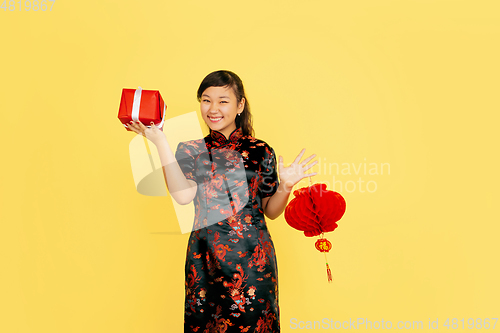 Image of Happy Chinese New Year. Asian young girls\'s portrait isolated on yellow background