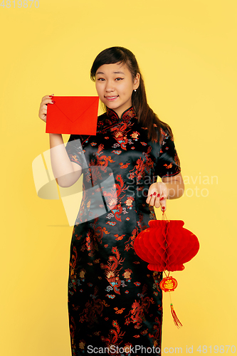 Image of Happy Chinese New Year. Asian young girls\'s portrait isolated on yellow background