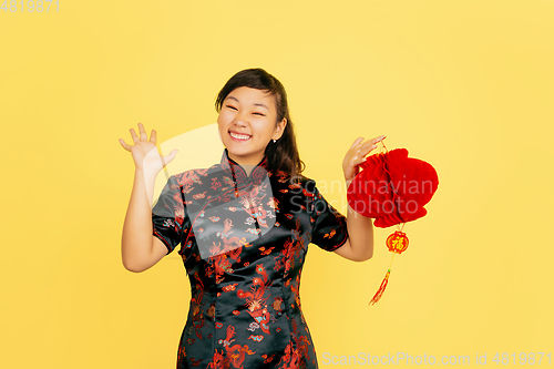 Image of Happy Chinese New Year. Asian young girls\'s portrait isolated on yellow background