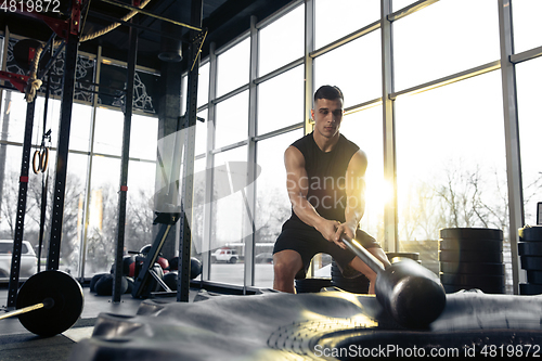 Image of The male athlete training hard in the gym. Fitness and healthy life concept.