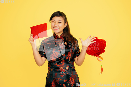 Image of Happy Chinese New Year. Asian young girls\'s portrait isolated on yellow background