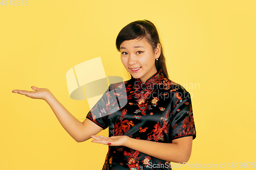 Image of Happy Chinese New Year. Asian young girls\'s portrait isolated on yellow background