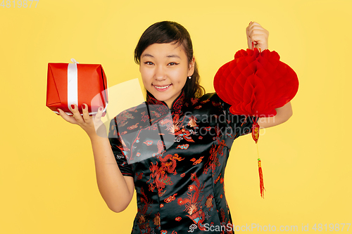 Image of Happy Chinese New Year. Asian young girls\'s portrait isolated on yellow background