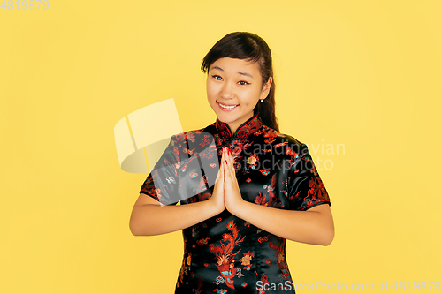 Image of Happy Chinese New Year. Asian young girls\'s portrait isolated on yellow background