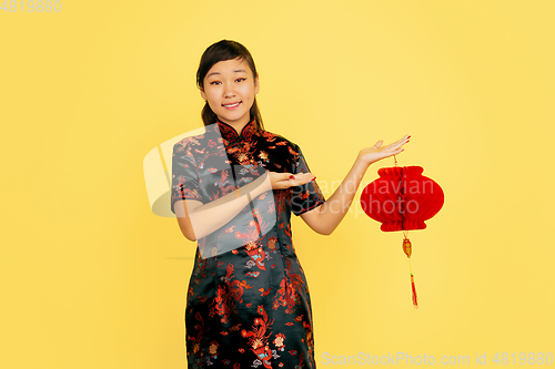 Image of Happy Chinese New Year. Asian young girls\'s portrait isolated on yellow background