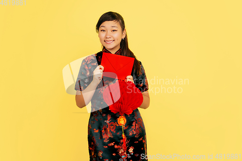 Image of Happy Chinese New Year. Asian young girls\'s portrait isolated on yellow background