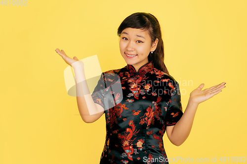 Image of Happy Chinese New Year. Asian young girls\'s portrait isolated on yellow background