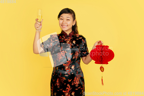 Image of Happy Chinese New Year. Asian young girls\'s portrait isolated on yellow background