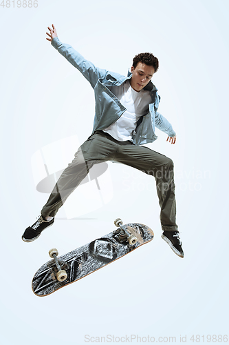 Image of Caucasian young skateboarder riding isolated on a white background