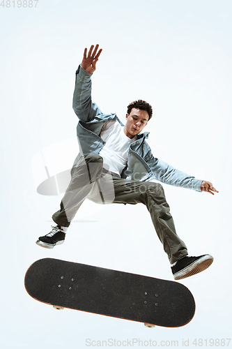 Image of Caucasian young skateboarder riding isolated on a white background