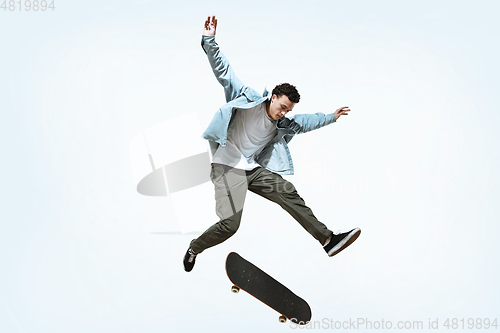 Image of Caucasian young skateboarder riding isolated on a white background