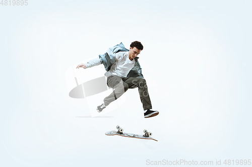 Image of Caucasian young skateboarder riding isolated on a white background