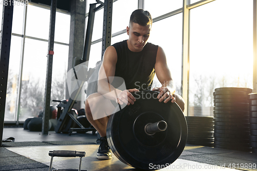 Image of The male athlete training hard in the gym. Fitness and healthy life concept.