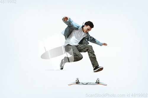 Image of Caucasian young skateboarder riding isolated on a white background