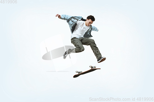 Image of Caucasian young skateboarder riding isolated on a white background