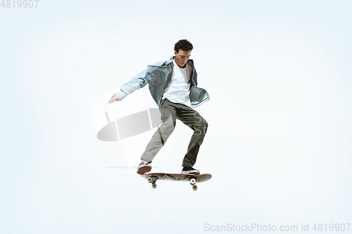 Image of Caucasian young skateboarder riding isolated on a white background