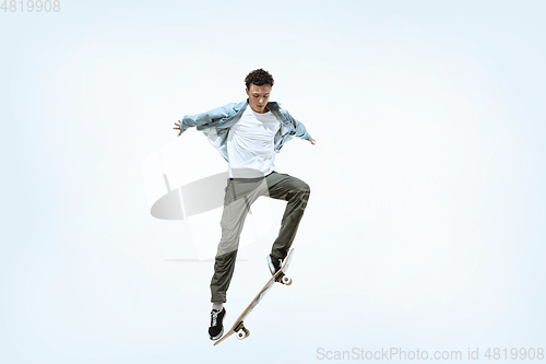 Image of Caucasian young skateboarder riding isolated on a white background