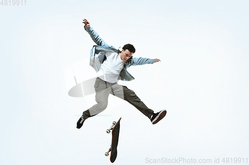 Image of Caucasian young skateboarder riding isolated on a white background