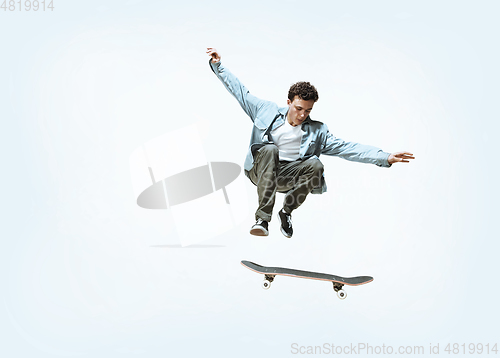 Image of Caucasian young skateboarder riding isolated on a white background