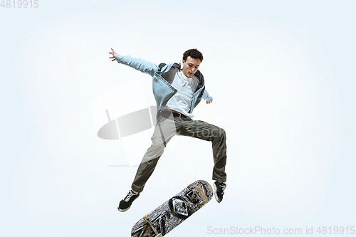 Image of Caucasian young skateboarder riding isolated on a white background