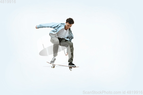 Image of Caucasian young skateboarder riding isolated on a white background