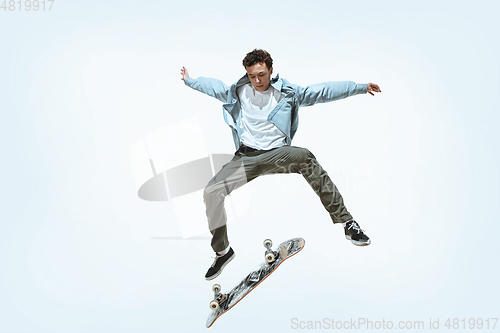 Image of Caucasian young skateboarder riding isolated on a white background