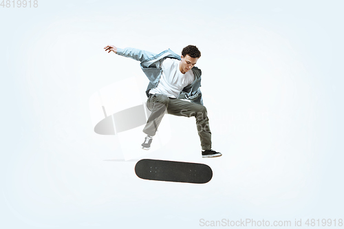 Image of Caucasian young skateboarder riding isolated on a white background