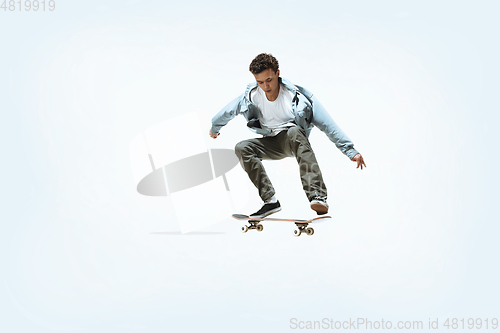 Image of Caucasian young skateboarder riding isolated on a white background