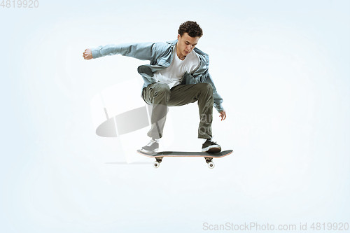 Image of Caucasian young skateboarder riding isolated on a white background