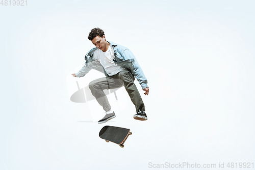 Image of Caucasian young skateboarder riding isolated on a white background