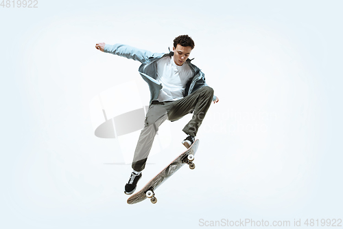 Image of Caucasian young skateboarder riding isolated on a white background