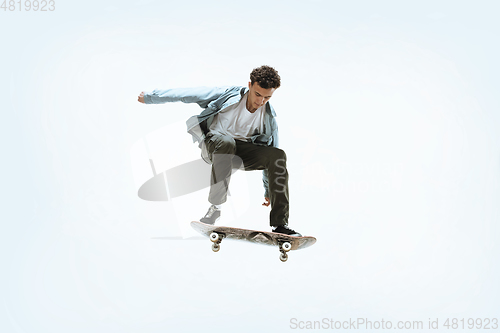 Image of Caucasian young skateboarder riding isolated on a white background