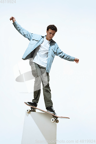 Image of Caucasian young skateboarder riding isolated on a white background