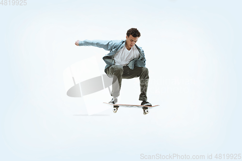 Image of Caucasian young skateboarder riding isolated on a white background