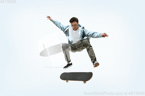 Image of Caucasian young skateboarder riding isolated on a white background