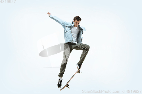 Image of Caucasian young skateboarder riding isolated on a white background