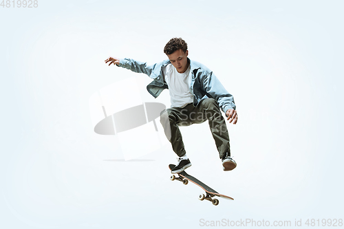 Image of Caucasian young skateboarder riding isolated on a white background