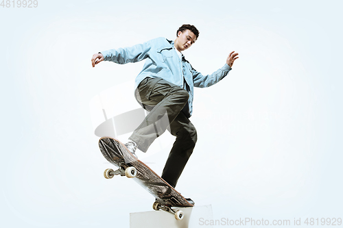 Image of Caucasian young skateboarder riding isolated on a white background