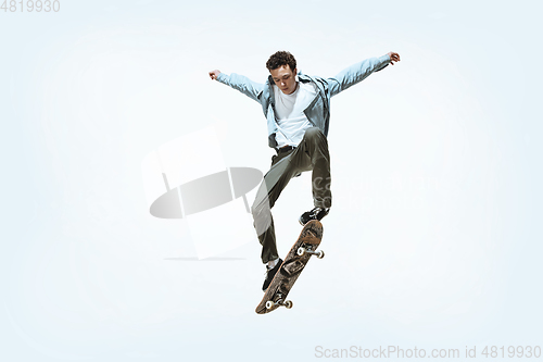 Image of Caucasian young skateboarder riding isolated on a white background