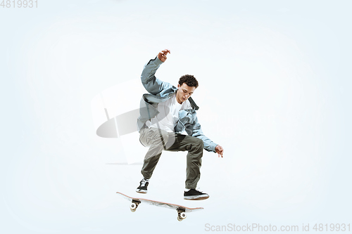Image of Caucasian young skateboarder riding isolated on a white background