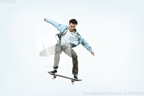 Image of Caucasian young skateboarder riding isolated on a white background