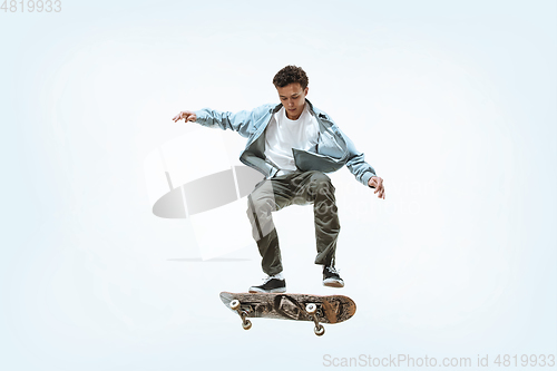 Image of Caucasian young skateboarder riding isolated on a white background