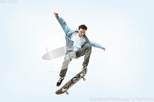 Image of Caucasian young skateboarder riding isolated on a white background