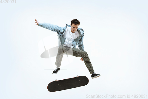 Image of Caucasian young skateboarder riding isolated on a white background