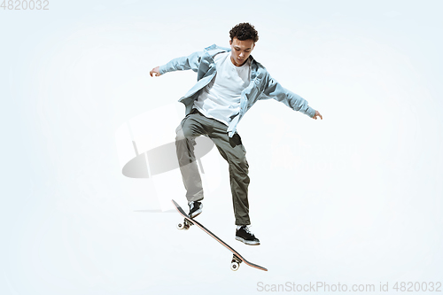 Image of Caucasian young skateboarder riding isolated on a white background