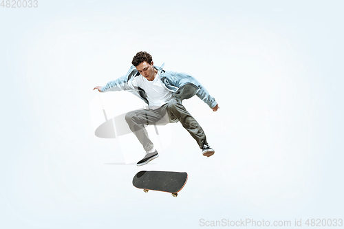 Image of Caucasian young skateboarder riding isolated on a white background